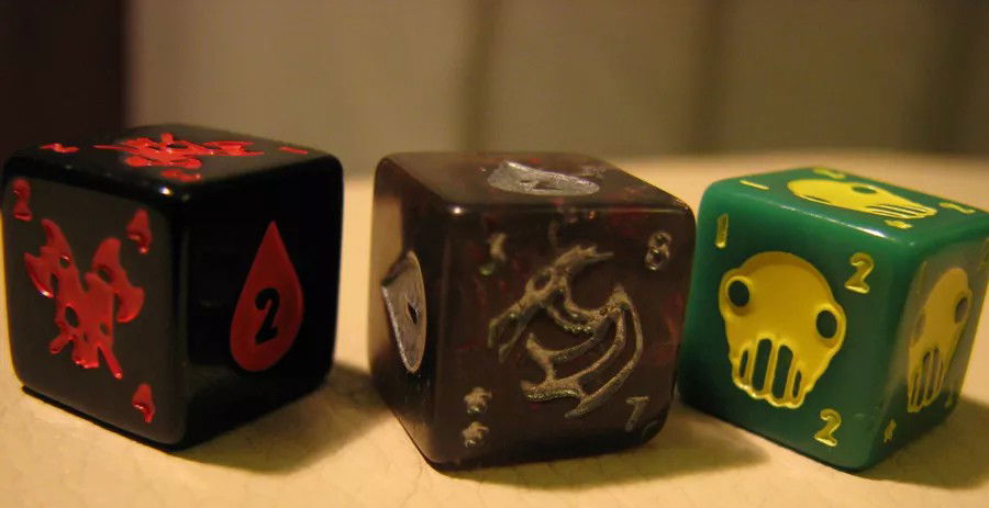 Dice depicting the Mighty Deathdealer, the Strong Quake Dragon, and the Scavenging Goblin